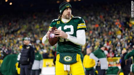 Rodgers throws a pass on the sideline before an NFL playoff game against the San Francisco 49ers.