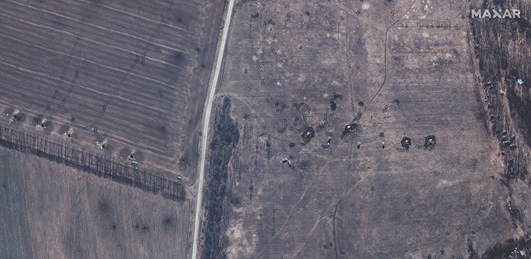 Russian self-propelled artillery in a field, its turrets turning towards the center of Izyum.
