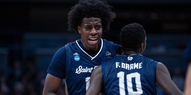 Saint Peter's Peacocks forward Clarence Robert and Foussini Dramatic (10) celebrate on the field during the second round of the NBA Men's Division I Basketball Tournament game against the Murray State Racers on March 19, 2022, at Ginbridge Fieldhouse in Indianapolis, Indiana.