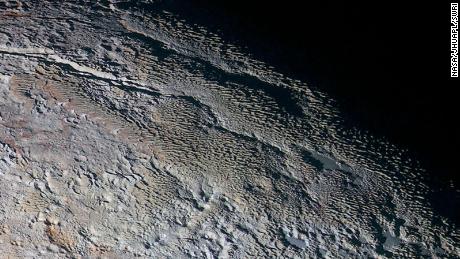 Pluto's snow-capped mountains look like they belong on Earth, but they're completely different