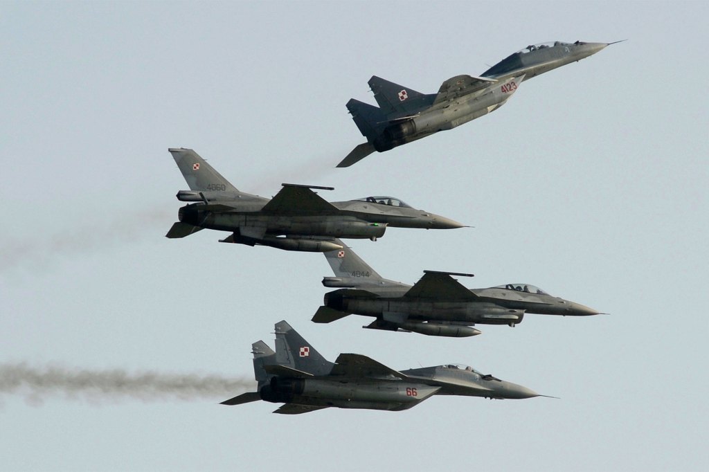 Two Russian Polish Air Force planes fly a MiG-29 over and under two Polish-US Air Force planes built F-16 fighter jets during the air show in Radom, Poland, on August 27, 2011.