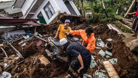 Villagers rescue items from damaged houses after a 5.6-magnitude earthquake in Cianjur on November 22, 2022. 